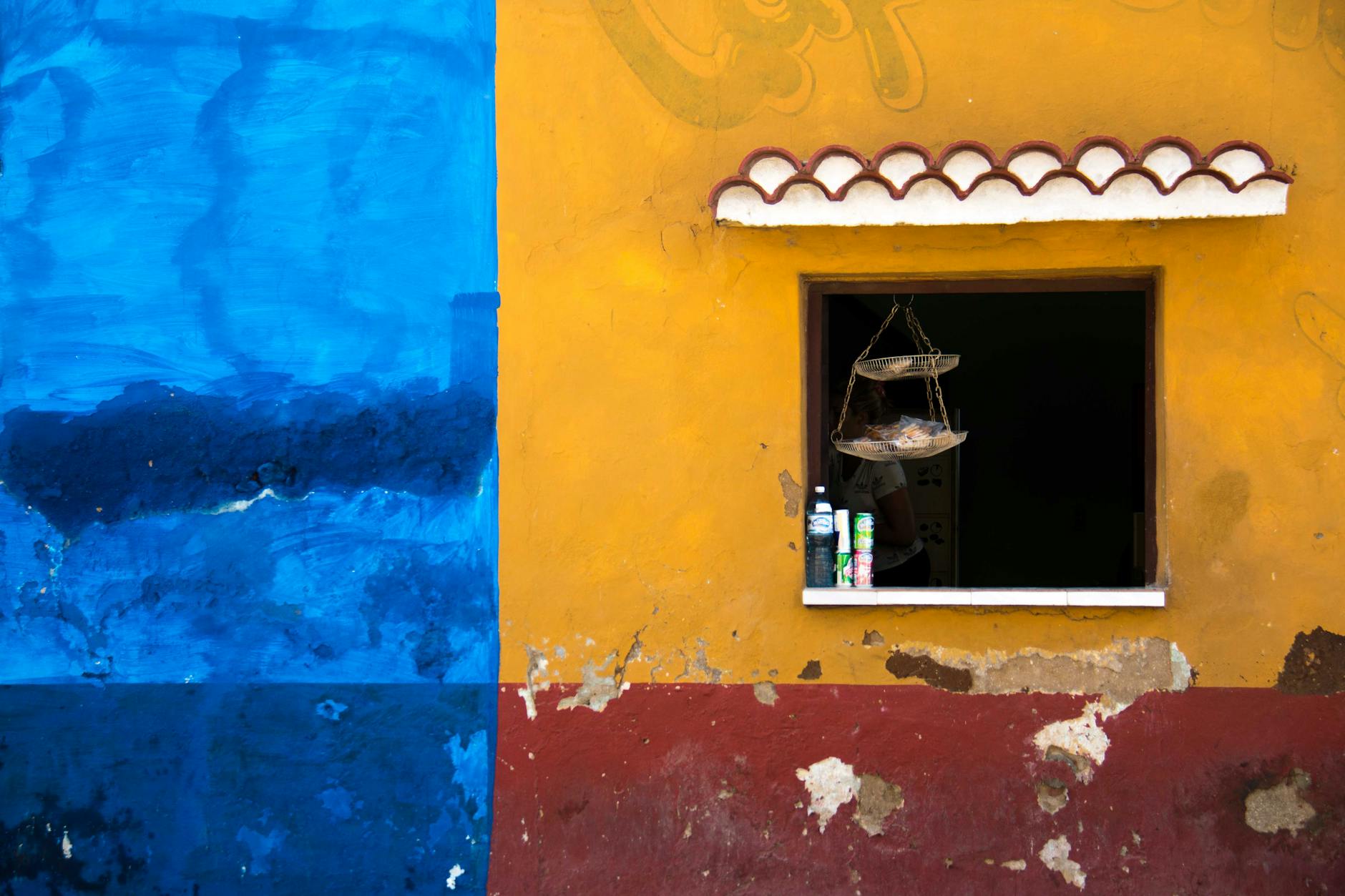 Niebiesko-żółta fasada z otwartym oknem w starym domu na ulicy