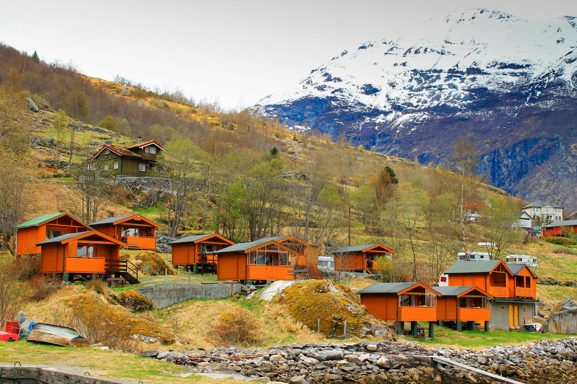 Norweska górska wioska z pomarańczowymi domkami nad wodą
