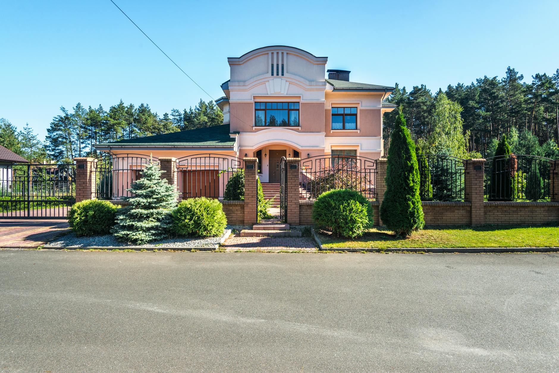 Nowoczesny dom z ogrodem i metalową bramą wjazdową